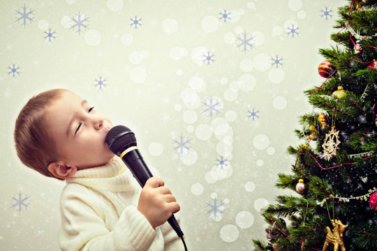 Junge singt vor Weihnachtsbaum